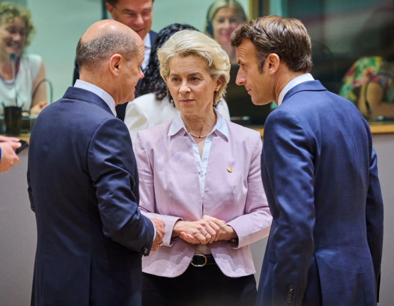 Three European leaders engaged in a serious conversation.